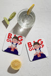 Two square coasters featuring an illustration of a child with pigtails holding a large drink with the text 'BIG GULP' in red, arranged on a textured white surface next to a glass of water, lime wedges, and a lemon slice.
