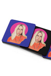 Product photograph of square coasters overlapping at an angle, featuring a vibrant portrait illustration of a blonde woman framed by a pink circle on a solid blue and black background, isolated against a clean white surface.