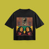 A flat-lay product photograph of a black t-shirt centered on a solid olive-green background. The shirt features a graphic print with a split design: the top section displays an illustration of a lion with the text 'I'm gonna be Iron like Lion in Zion,' while the bottom section features a mirrored portrait of Bob Marley against a red, yellow, and green background.