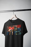Product photograph of a ltd edn oversized black t-shirt hanging on a wooden hanger against a plain grey background, featuring a graphic print of the artist deadmau5 with a stylized character, a boombox, and textured, collage-style background elements.