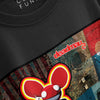 A close-up, angled product shot of a black t-shirt showing the details of the graphic print, which features the 'deadmau5' logo in stylized red and white lettering above a large, vibrant red mouse-ear mascot character set against a textured, industrial, and collage-style background.