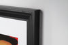 Close-up of a classy black framed art print on a white wall