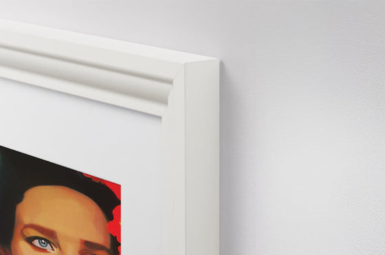 closeup of a classy white framed painting of a gorgeous woman with beautiful eyes, hanging on a light gray wall
