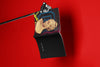 Product lifestyle photograph of an art cover sketchbook featuring the IDEAL FEMALE HEAD 'IFH B' portrait design by Nemozine, suspended against a vibrant red background.