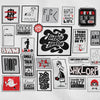 An extreme close-up of a white fabric print showing a detailed grid of collage-style graphic designs and text art. The illustrations feature a mix of pop art, cartoon figures, and witty or irreverent text phrases like 'Fuckin Tastic', 'BUY ART NOT COCAINE', and 'CRASH THE PARTY Not Your Car' in a black, white, and red color scheme.