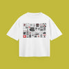A flat-lay product photograph of a white t-shirt centered on a solid olive-green background. The shirt features a large rectangular graphic print composed of a grid of numerous small, distinct sticker-style illustrations, symbols, and typographic designs in black, white, and red.