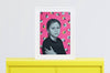 Lifestyle product photograph of the limited edition archival art print RESILIENCE by Nemozine, displayed in a white frame resting on a vibrant yellow surface.