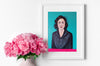 Lifestyle product photograph of the limited edition archival art print ZAHIR by Nemozine, displayed in a white frame next to a light pink vase filled with vibrant pink flowers.
